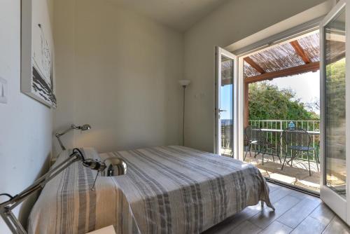 a bedroom with a bed and a large window at Il Quartiere apt Giglio in Pomonte