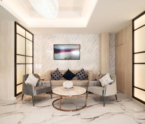 a living room with a couch and two chairs and a table at Lucky Hotel Bangkok in Khlong Toei