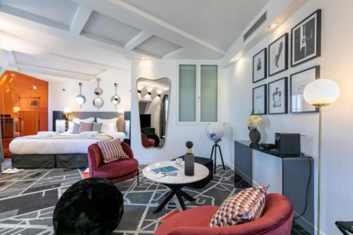 a bedroom with a bed and two chairs and a table at Sublim by Sweett in Paris