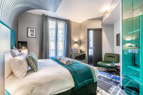 1 dormitorio con 1 cama grande y 1 silla verde en Sublim by Sweet Inn, en París
