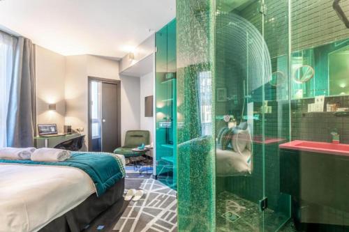 La salle de bains est pourvue d'une douche en verre avec un lit et un lavabo. dans l'établissement Sublim by Sweet Inn, à Paris