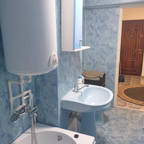 RazDav Straja Central في Lupeni: حمام به حوض غسيل أبيض ومرآة