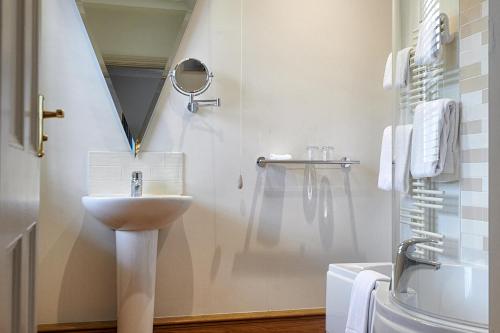 a white bathroom with a sink and a mirror at The Beeley Inn - Chatsworth in Beeley