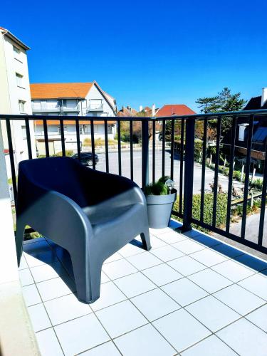 a bench sitting on a balcony next to a fence at L'art de l'eau PLage ,Studio en résidence privée. in Neufchâtel-Hardelot