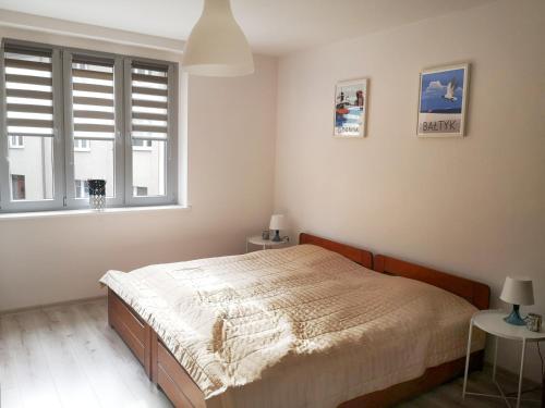 a bedroom with a bed and a window at Apartament śródmiejski in Gdańsk