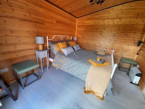 a bedroom with a bed and a wooden wall at The Hut B & B in Mochdre