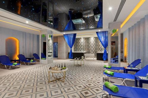 a waiting room with blue chairs and a piano at Pickalbatros Blu Spa Resort - Adults Friendly 16 Years Plus- Ultra All-Inclusive in Hurghada