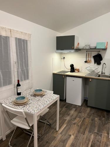 une petite cuisine avec une table et un évier dans l'établissement L'Arcachonaise - Studio cosy avec jardin à Bègles, à Bègles