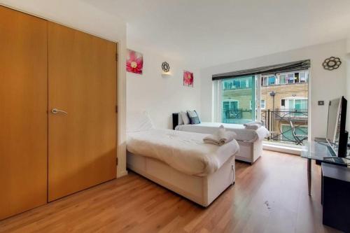 a bedroom with two beds and a large window at Excel London City Airport Seagull Lane Royal Victoria 2 Bedrooms Apartments in London