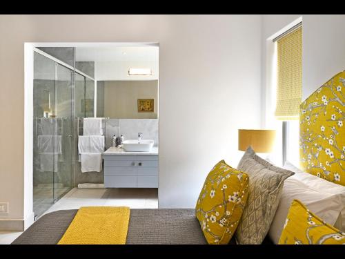 Habitación con baño con cama y lavabo. en Small Wonder, en Franschhoek