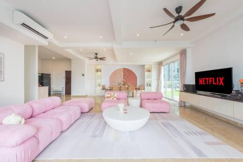 a living room with a pink couch and a tv at Penthouse Hermès in Kuala Lumpur