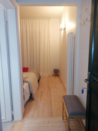 a small room with a bed and a wooden floor at LES JARDINS CELESTES in Saint-Genest-de-Bauzon