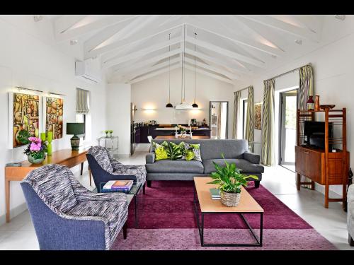a living room with a couch and chairs and a table at Small Wonder in Franschhoek