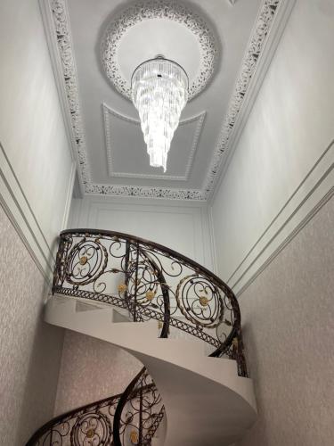 a staircase with a chandelier and a ceiling at Sapphire hotels in Taraz