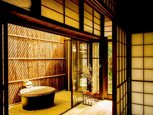 a room with a bath tub and a window at Udatsuya in Osaka