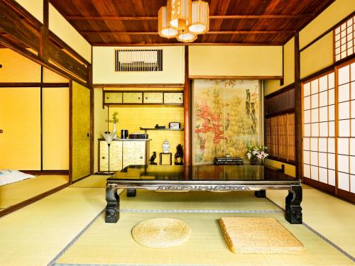 una habitación con una mesa en el medio de una habitación en Udatsuya en Osaka