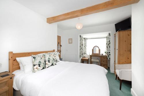a bedroom with a white bed and a desk at The Nest - Cosy Holiday Cottage in Errol