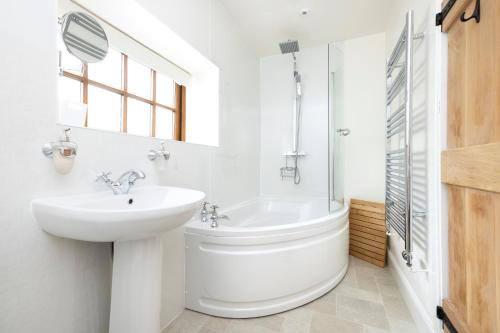 a bathroom with a sink and a toilet and a tub at The Nest- Cosy Holiday Cottage in Errol