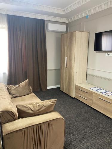 sypialnia z łóżkiem, telewizorem i szafką w obiekcie Sapphire hotels w mieście Taraz