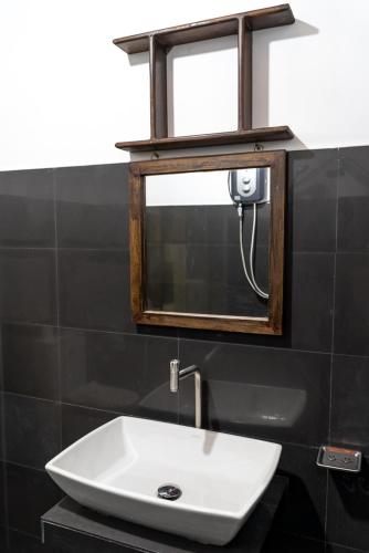 a white sink in a bathroom with a mirror at Luvi Lucas River Side in Weligama