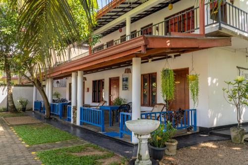 a house with a balcony and a patio at Luvi Lucas River Side in Weligama