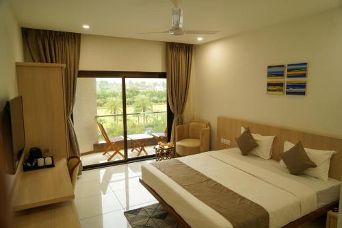 una habitación de hotel con cama y balcón en Arawali Ananta Elite, Ranakpur, en Sādri