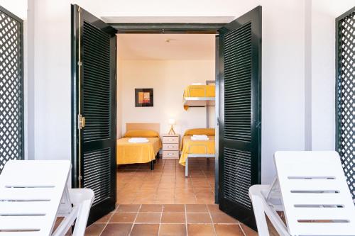 プンタ・ウンブリアにあるAlbergue Inturjoven Punta Umbríaのベッド2台と二段ベッド1組が備わる客室です。