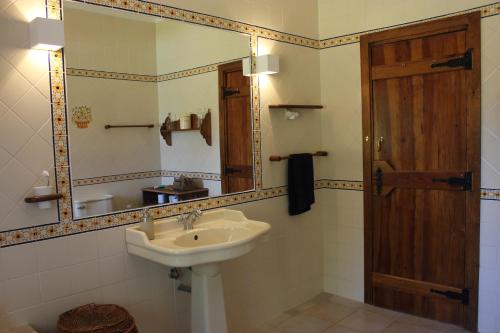 y baño con lavabo y espejo. en Monte do Pinheirinho, en São Domingos
