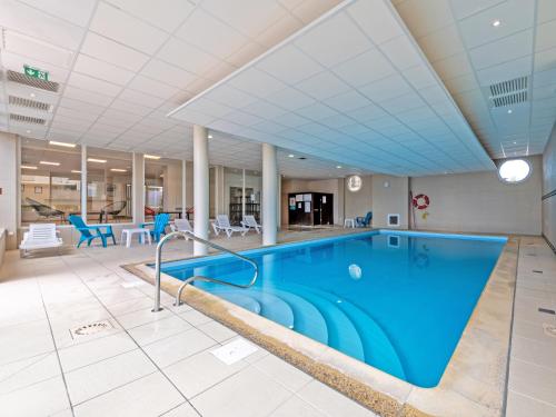 - une grande piscine dans un bâtiment doté d'un grand plafond dans l'établissement Vacancéole - Le Domaine de Bertheaume, à Plougonvelin