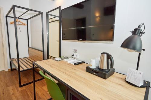 a room with a desk with a mirror and a lamp at Hotel Garden Court in Prague