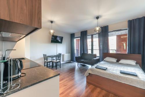 um quarto com uma cama e uma cozinha com uma mesa em Apartament z balkonem blisko Starego Miasta em Gdansk