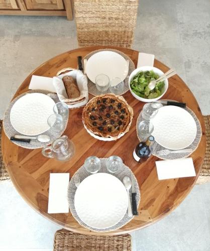 a wooden table with plates and food on it at LES JARDINS CELESTES in Saint-Genest-de-Bauzon