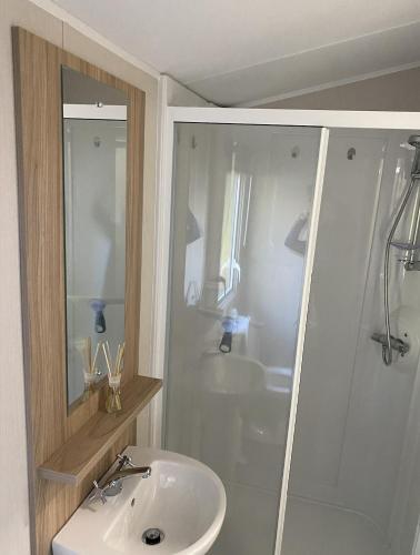 a bathroom with a white sink and a shower at KellysHolidayHomes 26 Willerby 2 bedrooms caravan in Weeley