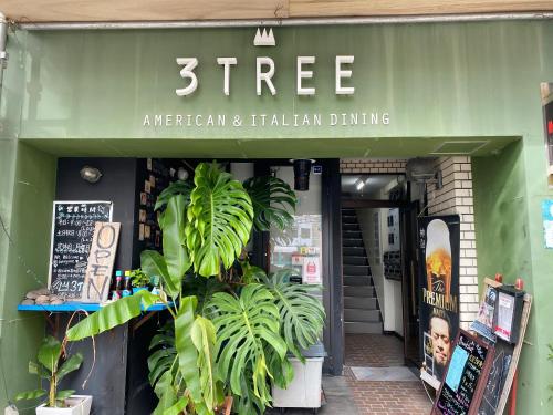 a store with a green awning and plants in front at Takanobashi HOTEL in Hiroshima