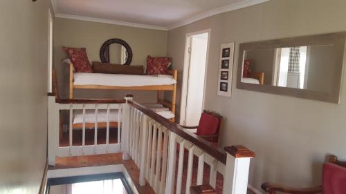 a room with a staircase with a bunk bed and a mirror at Umzimkulu River Lodge in Underberg