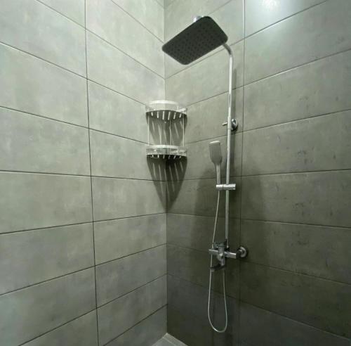 y baño con ducha con cabezal de ducha. en Sapphire hotels en Taraz