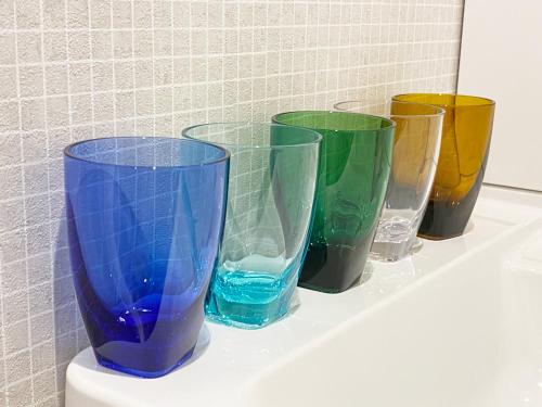 a row of different colored vases sitting on a shelf at Takanobashi HOTEL in Hiroshima