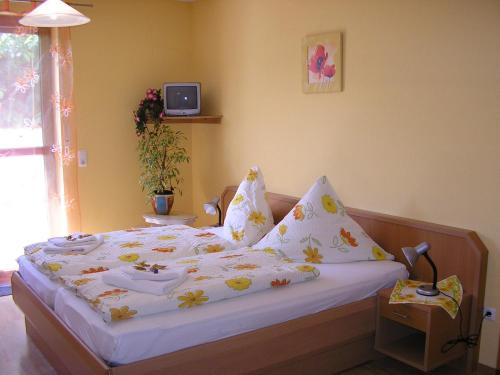 a bedroom with a bed with white sheets and pillows at Pension Lindenallee in Neuendettelsau