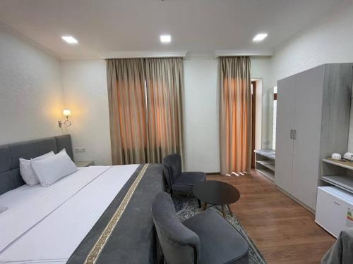 a hotel room with a large bed and a table at Registon Saroy Hotel in Samarkand