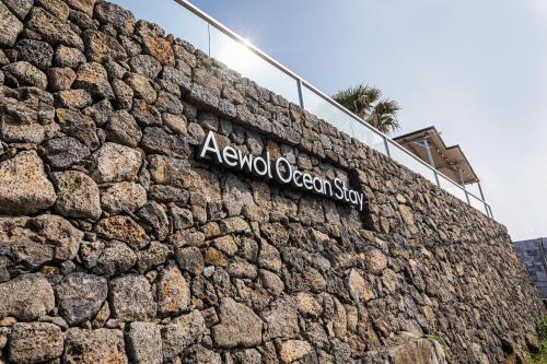 a stone wall with a sign on top of it at Aewol Oceanstay in Jeju