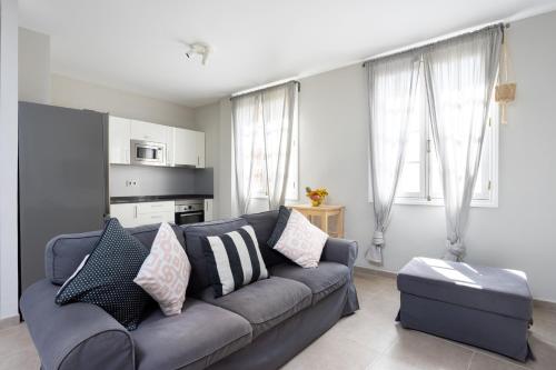 a living room with a blue couch and some windows at Home2Book Cozy Apartment Santa Cruz Skyline in Santa Cruz de Tenerife