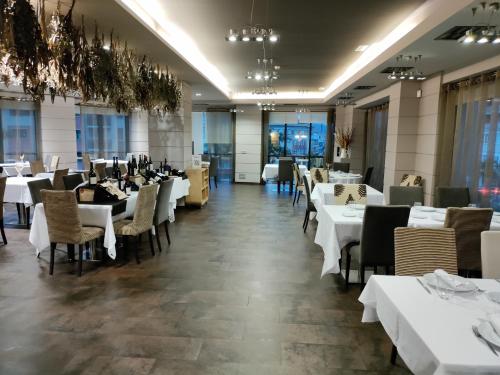 a dining room with white tables and chairs at Hotel Bienestar Moaña in Moaña