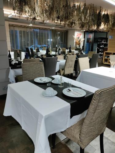 a dining room with white tables and chairs at Hotel Bienestar Moaña in Moaña