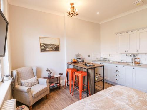 a room with a kitchen and a table and a chair at Lewis Hunton Suite in Saltburn-by-the-Sea