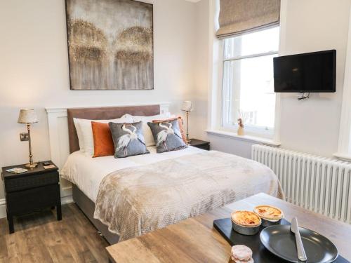 a bedroom with a bed with a table and a tv at Lewis Hunton Suite in Saltburn-by-the-Sea
