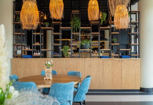 a dining room with blue chairs and a table at POLANKI AQUA Apartamenty PREMIUM - w cenie nielimitowany dostęp do strefy Aqua in Kołobrzeg