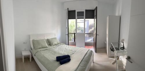 a white bedroom with a large bed with blue pillows at Tantulia Callao 57 Apto 5hab centro de la capital en tenerife in Santa Cruz de Tenerife
