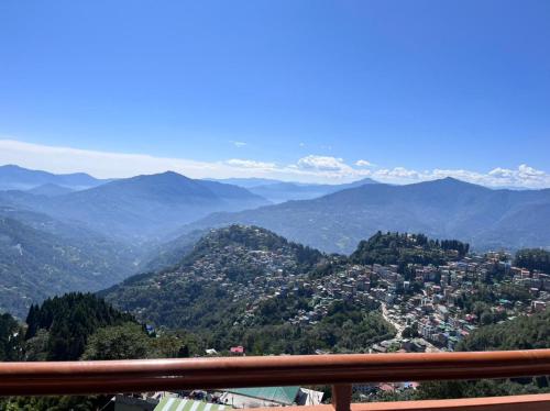 a view of a city from a balcony with mountains at The Sherpa's Abode in Gangtok