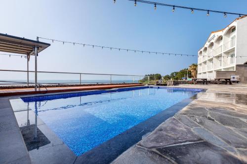 a swimming pool with the ocean in the background at Aewol Oceanstay in Jeju
