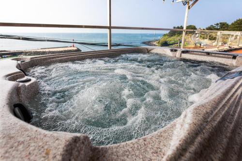 a jacuzzi tub with a view of the ocean at Aewol Oceanstay in Jeju